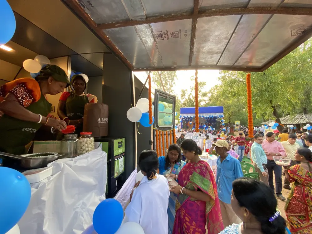 Women serving refreshments from the open counter beside the eLoo pilot